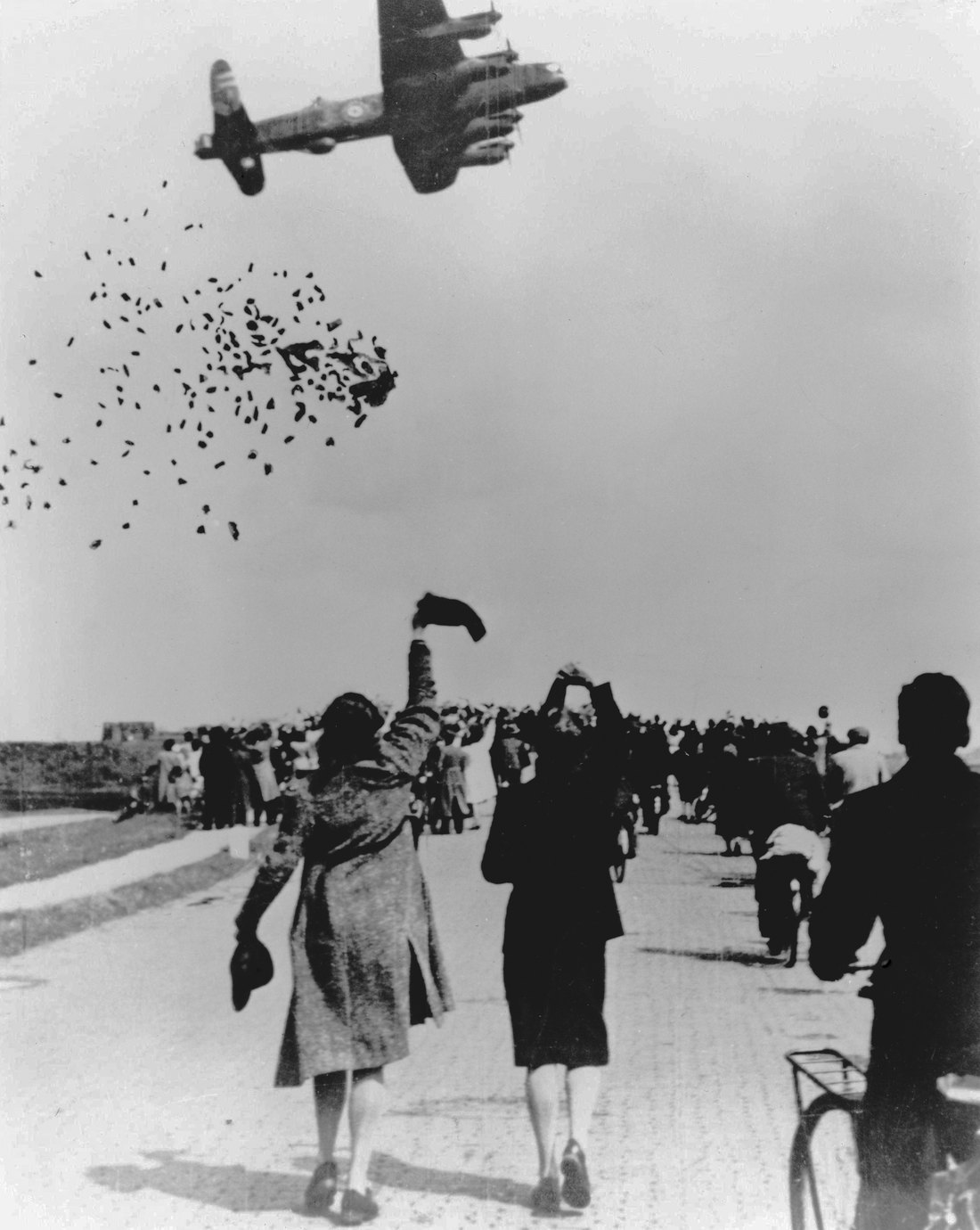 Lancaster bomber releasing food packages at low altitude